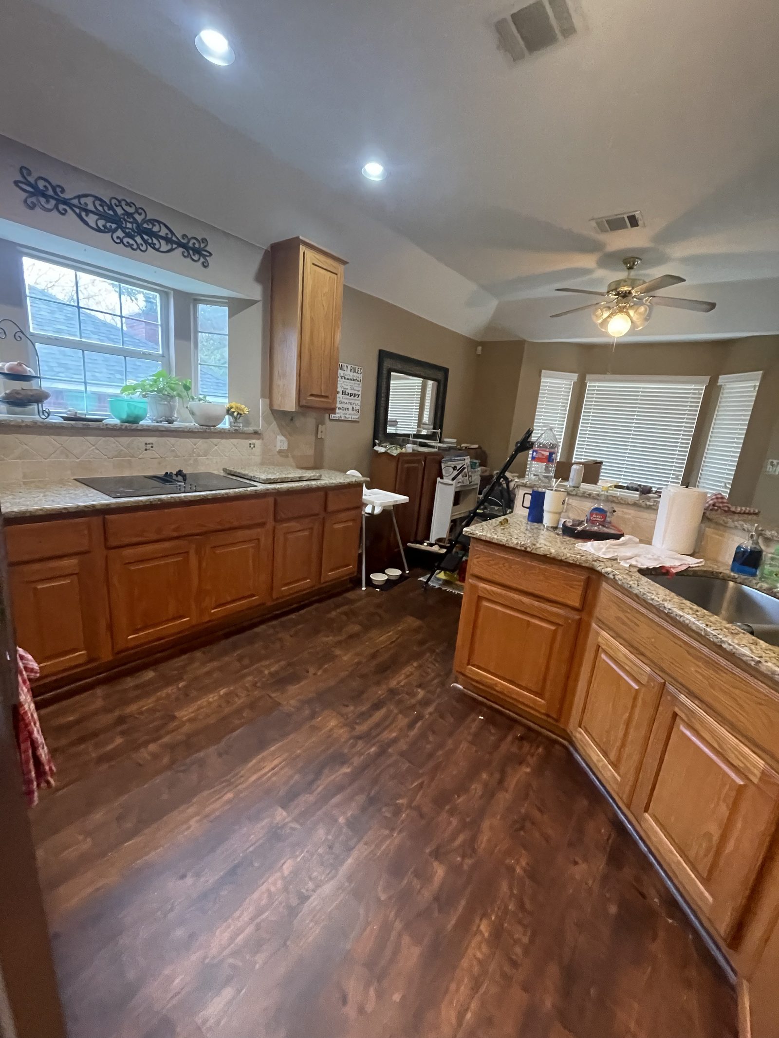 Kitchen before, cooktop wall with bay window and a patterned valance