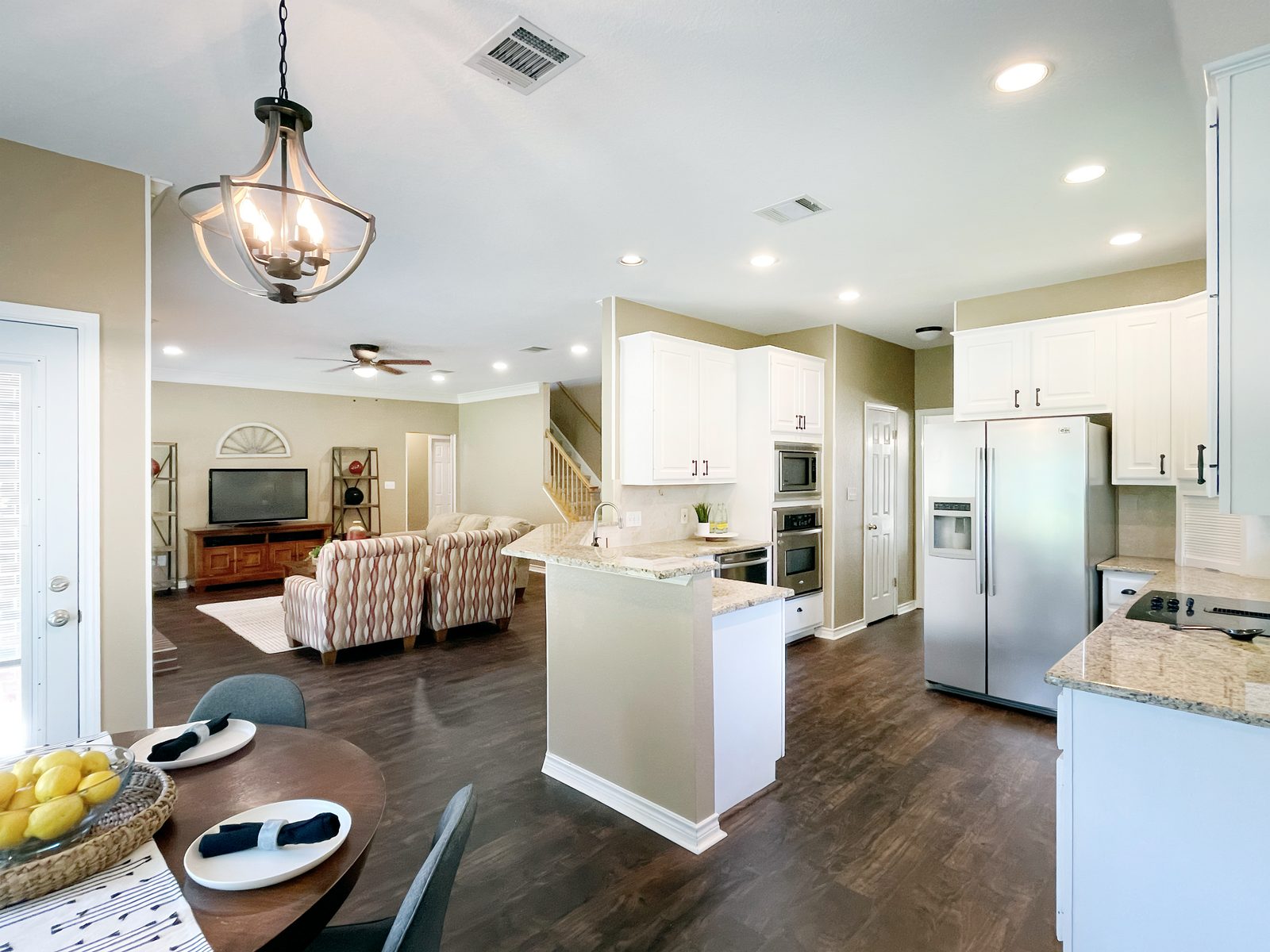 Kitchen and dining after painting, with white cabinets and granite counters