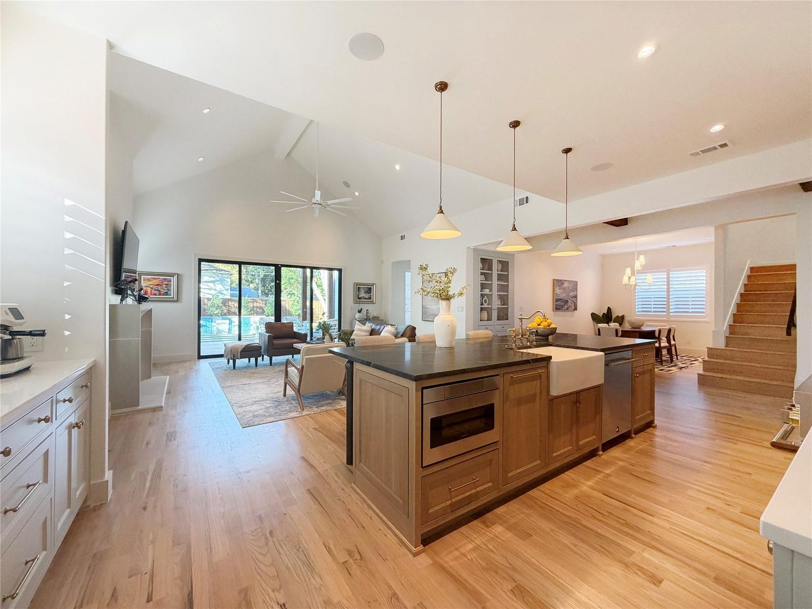 Open kitchen with island, farmhouse sink and vaulted ceiling