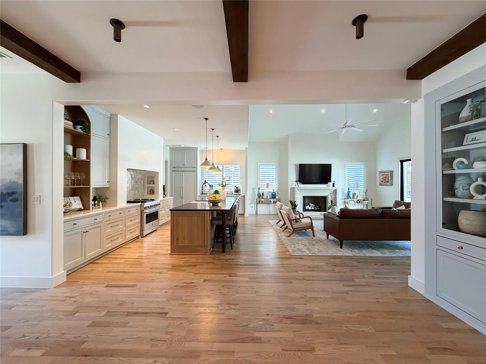 Open plan kitchen and living room with beamed ceiling and white oak floors