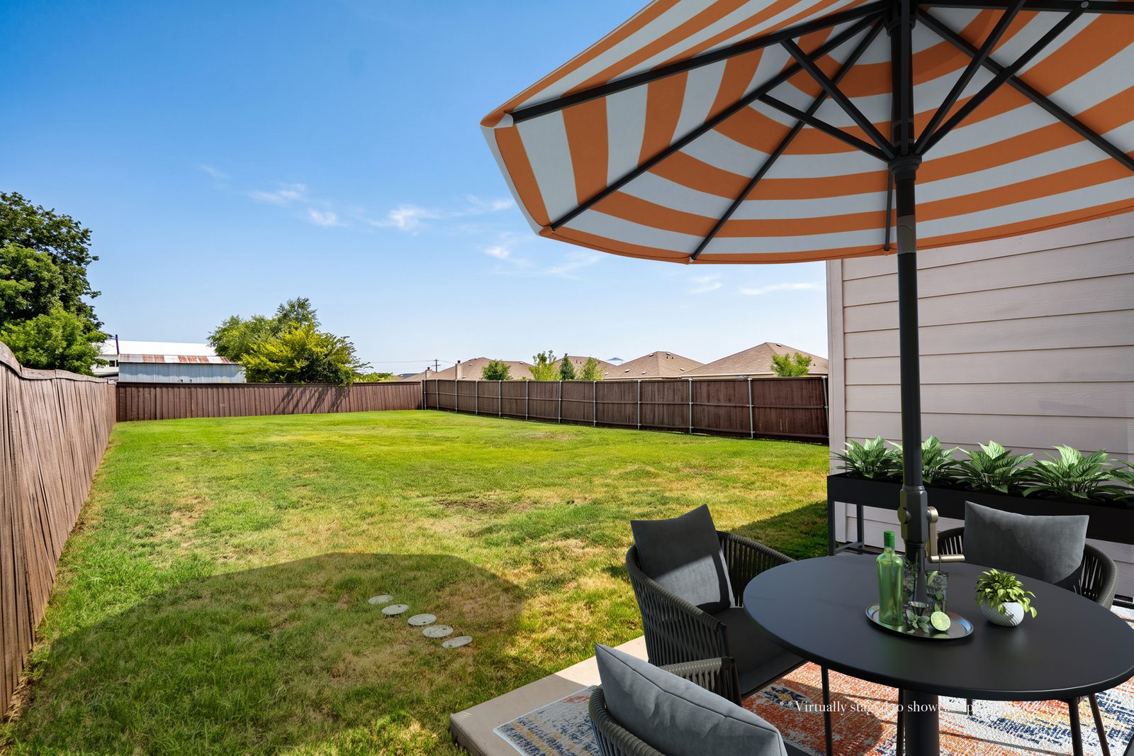 Back patio virtually staged with table, chairs and umbrella